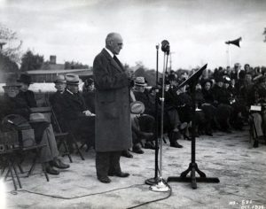 Western’s first president, Henry Hardin Cherry, speaks at a microphone in October 1936 as the cornerstone is laid for the building that – about a year later, following his death – becomes dedicated to him and named Cherry Hall.